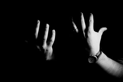 Close-up of hands against black background