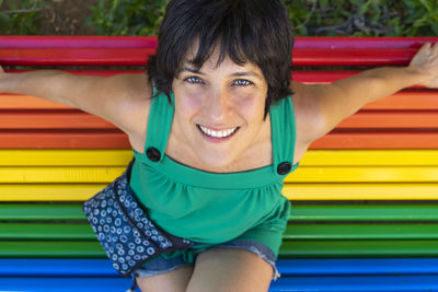 Portrait of smiling woman sitting on bench