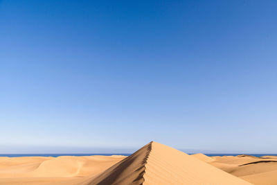 Low angle view of sand dunes against the sky at maspalomas on gran canaria 