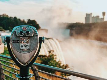 Close-up of coin-operated binoculars against cityscape