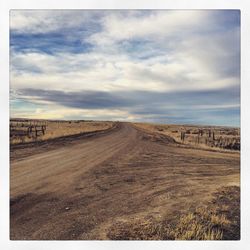 Road by landscape against sky