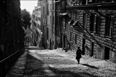 Rear view of man walking on street in city