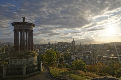 Buildings in city against cloudy sky
