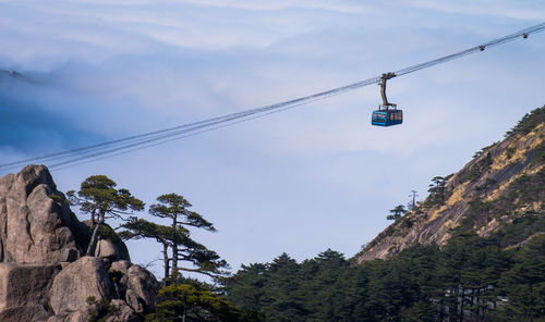 Low angle view of overhead cable car against sky