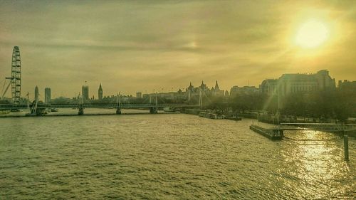 Sunset over river with cityscape in background