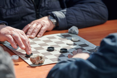 Midsection of man playing chess