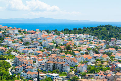 High angle view of town by sea against sky