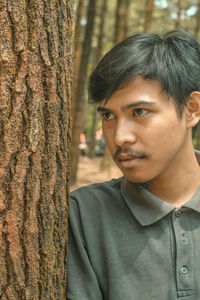 Close-up portrait of young man in forest