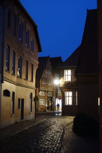 Street amidst buildings against sky at night