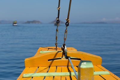 Rope tied to metal pole against sea