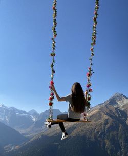 Rear view of woman swinging at playground