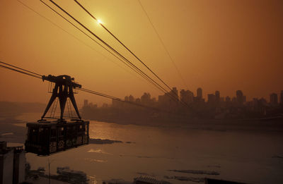 View of overhead cable car against clear sky at sunset