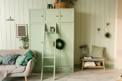 Cozy christmas bedroom interior with mint wardrobe and sofa. new year's home decor