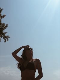 Low angle view of woman standing against sky