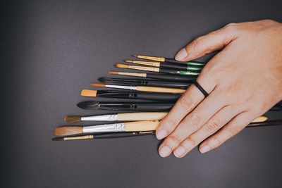 Close-up of hand holding stack of table