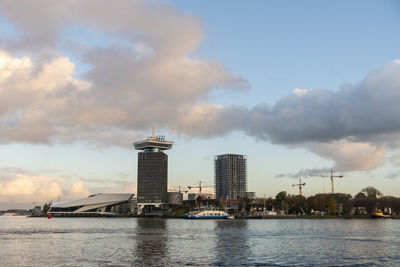 Sea by buildings against sky