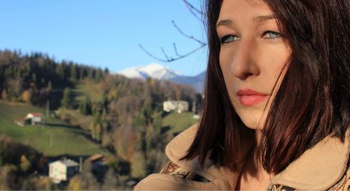 Close-up portrait of beautiful woman against sky