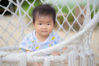 Portrait of cute baby girl behind fence