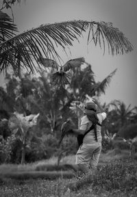 Side view of woman on field against trees