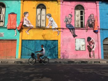 People sitting on bicycle against building