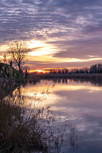 Scenic view of lake against sky at sunset