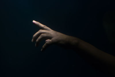 Close-up of hand over black background