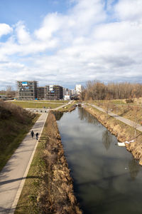 Bridge over canal in city against sky