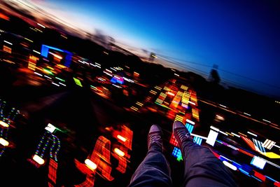 Low section of person against illuminated city at night