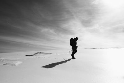 Full length of man climbing on sand against sky