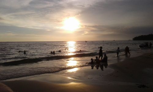 People on beach at sunset