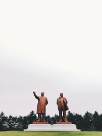 Rear view of couple standing against clear sky