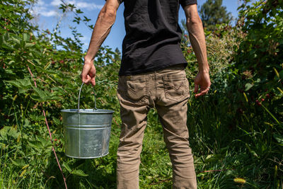 Midsection of man working by plants