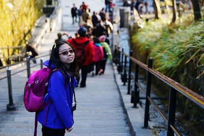 Portrait of teenage girl with backpack standing on staircase