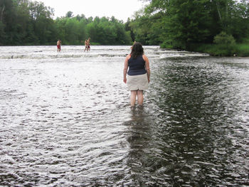 Rear view of woman standing in water