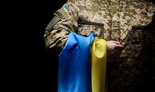 Midsection of man standing against black background