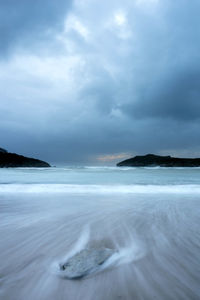 Scenic view of calm sea against cloudy sky