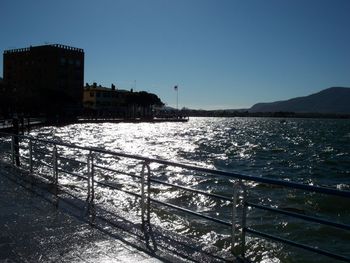 Scenic view of sea by buildings against clear sky