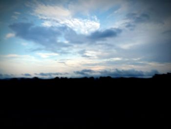 Silhouette landscape against cloudy sky