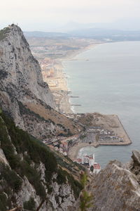 High angle view of sea by mountain against sky