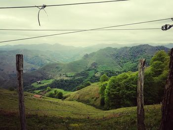 Overhead cable car over mountains against sky