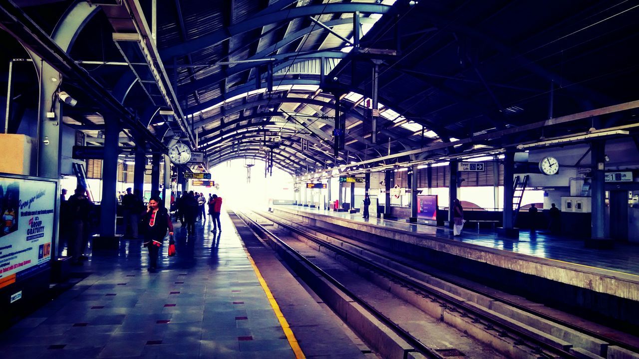 railroad track, railroad station platform, railroad station, rail transportation, public transportation, transportation, architecture, built structure, train - vehicle, indoors, travel, incidental people, illuminated, passenger train, mode of transport, the way forward, subway station, men, railway station