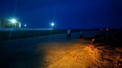 Illuminated street lights against clear sky at night