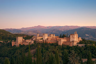 Panoramic view of buildings and mountains against clear sky