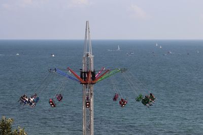 Scenic view of sea against sky with fairground ride