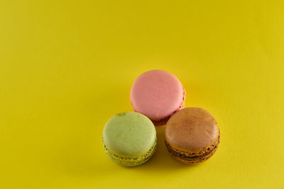 Close-up of multi colored candies against yellow background