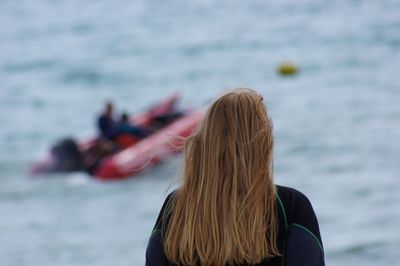 Rear view of woman standing against sea