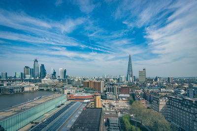 High angle view of city buildings against cloudy sky