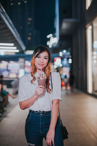 Portrait of young woman standing outdoors