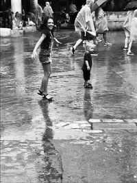 Girl with brother standing on footpath during rainy season