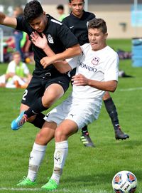 Full length of friends playing soccer on field